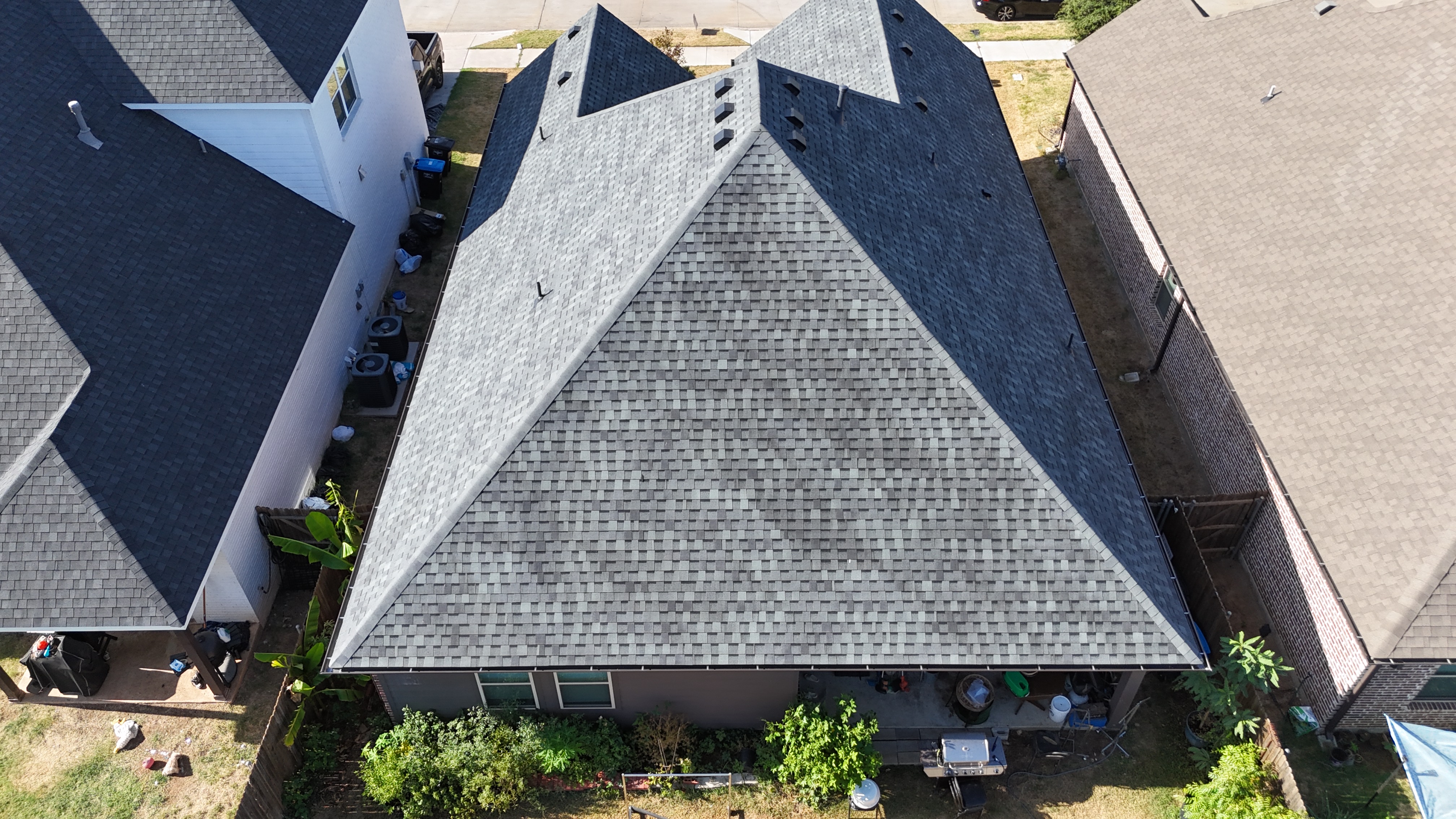 Overhead aerial view of completed gray roof on red brick home