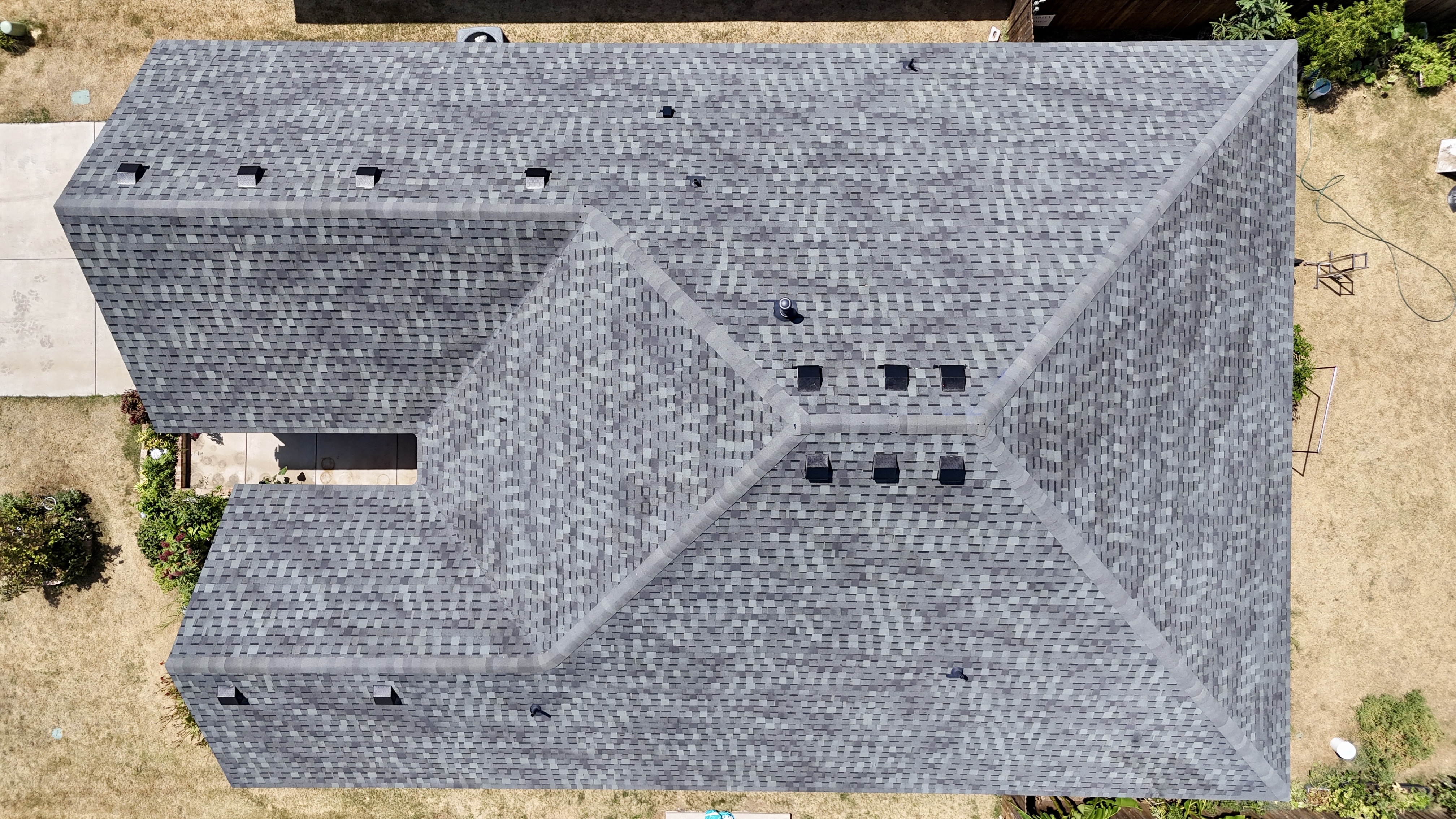 Top-down aerial view of completed gray shingle roof