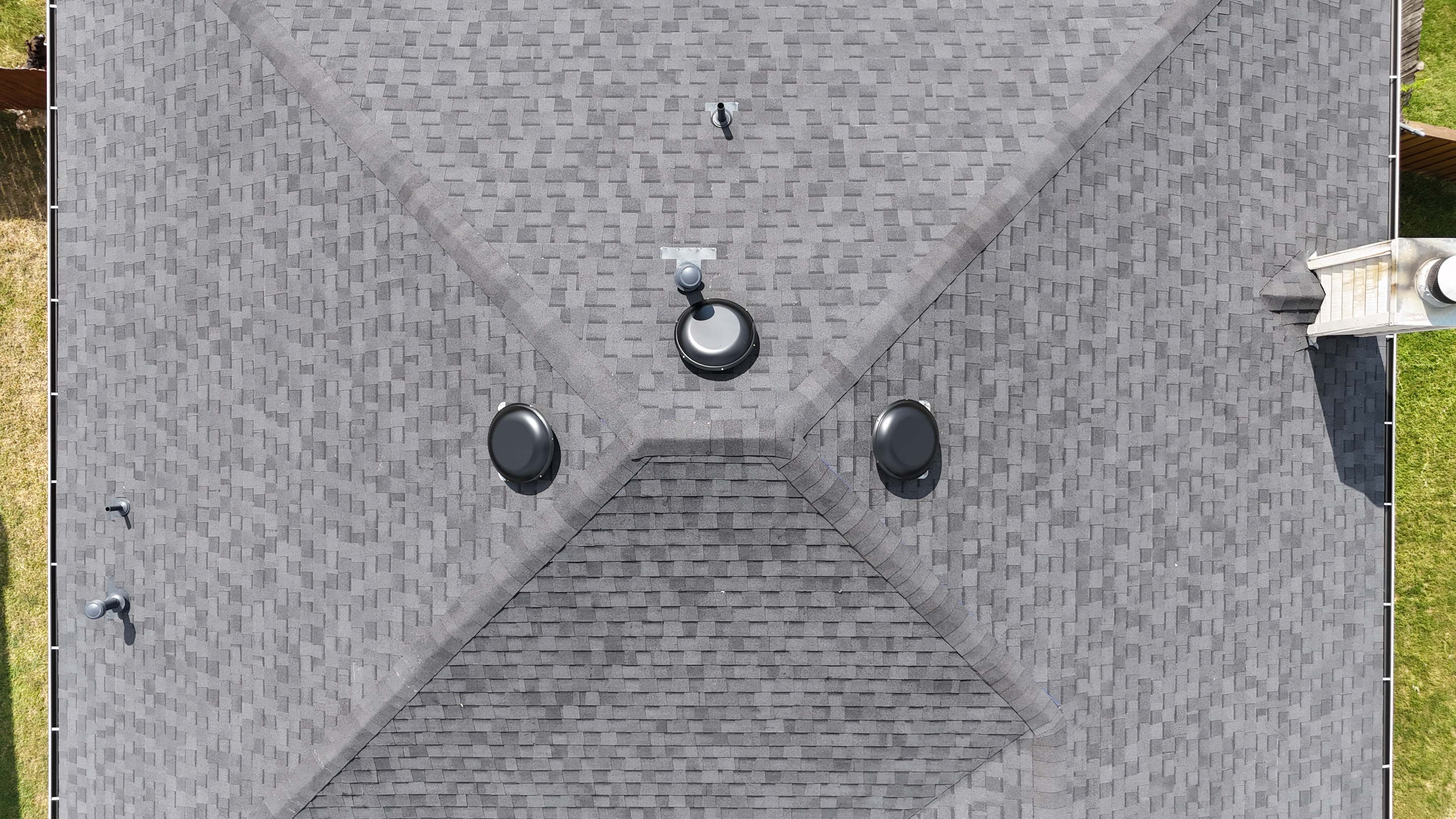 Top-down aerial of completed charcoal roof with turbine and dome vents