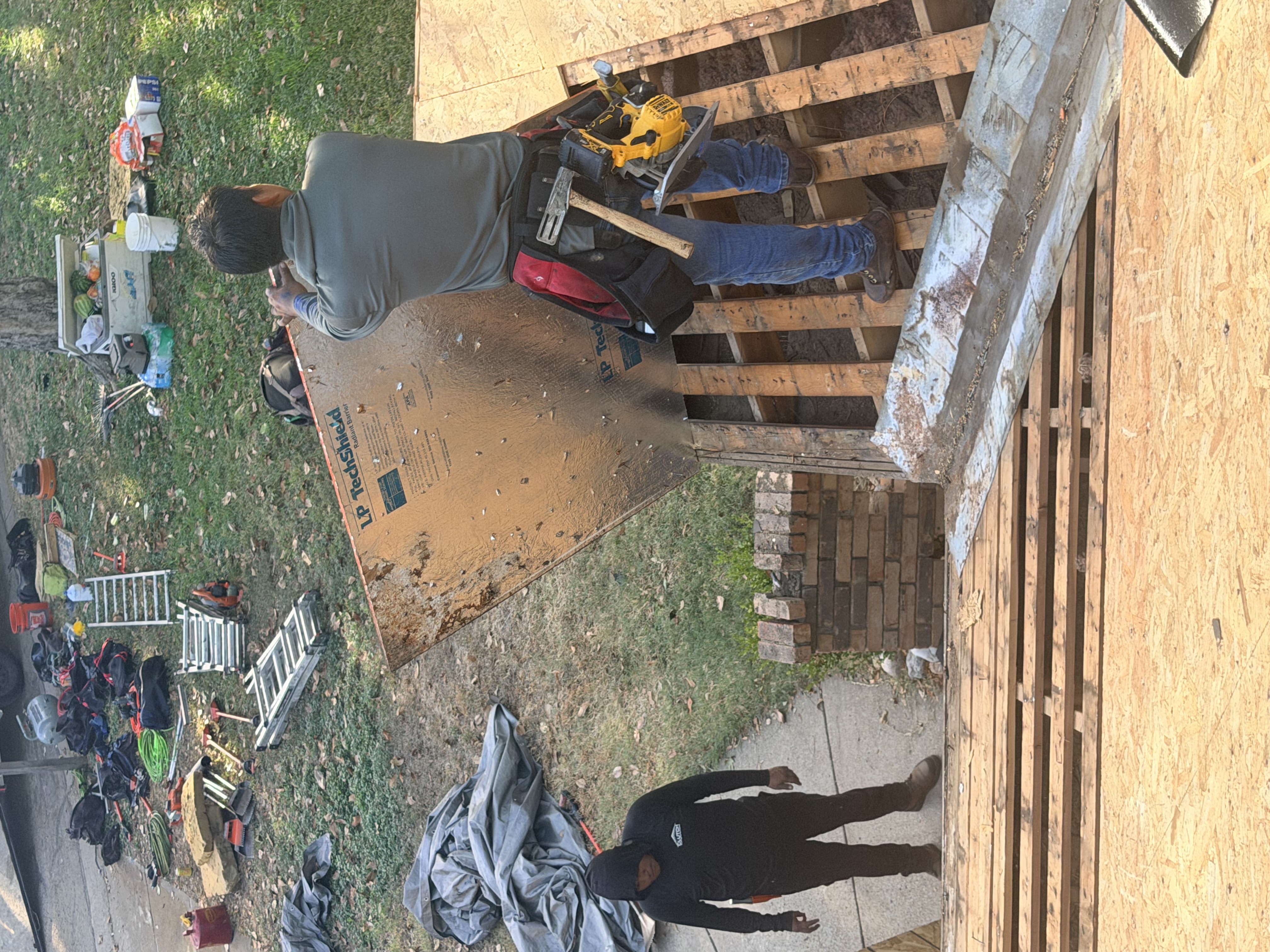 Roofing crew installing new radiant barrier decking during tear-off