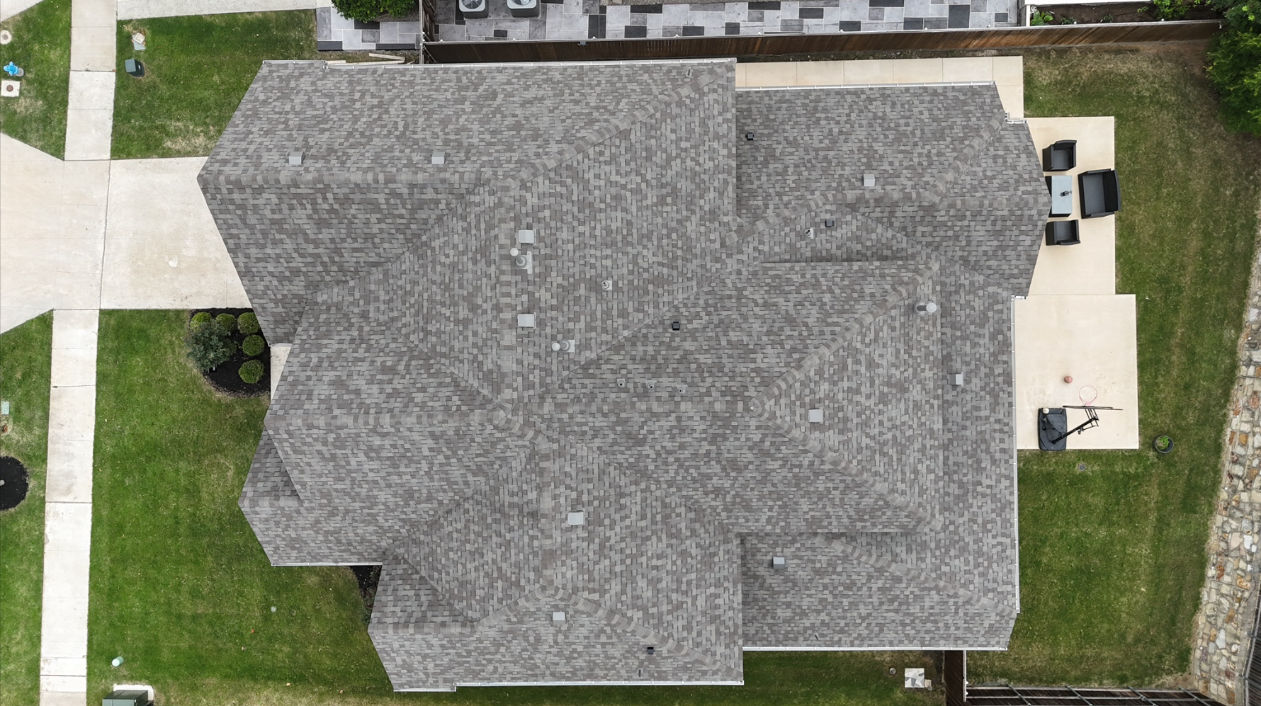 Top-down aerial of large completed gray shingle roof