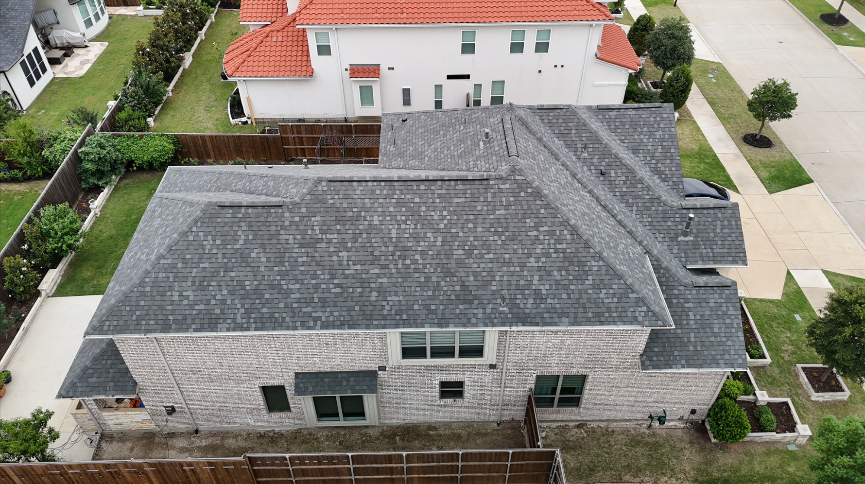 Aerial view of completed single-story home with new gray shingles
