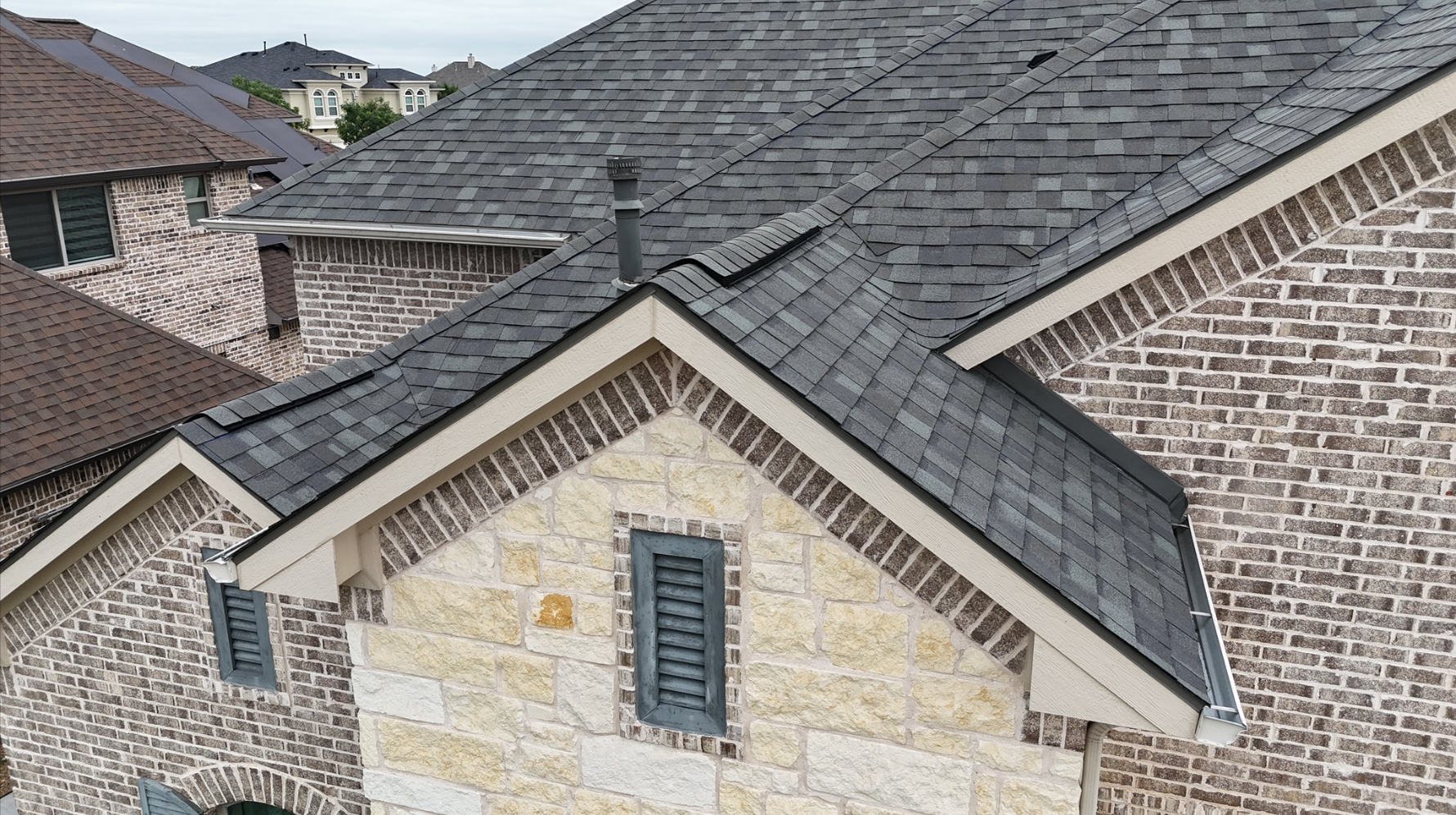Completed roof on stone and brick Texas home