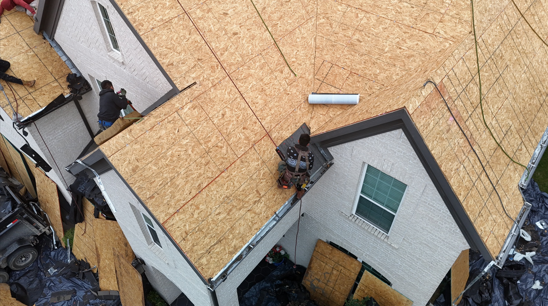 Crew members working on new OSB roof decking installation