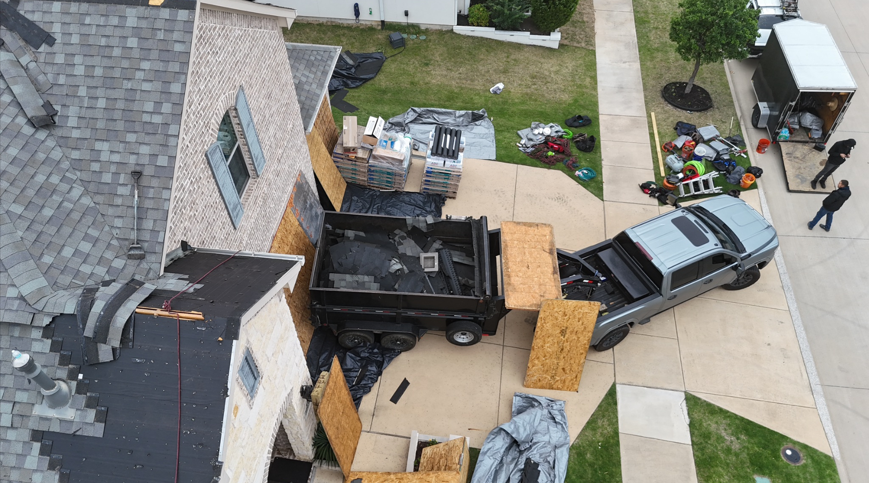 Aerial view of roofing job site with materials and equipment