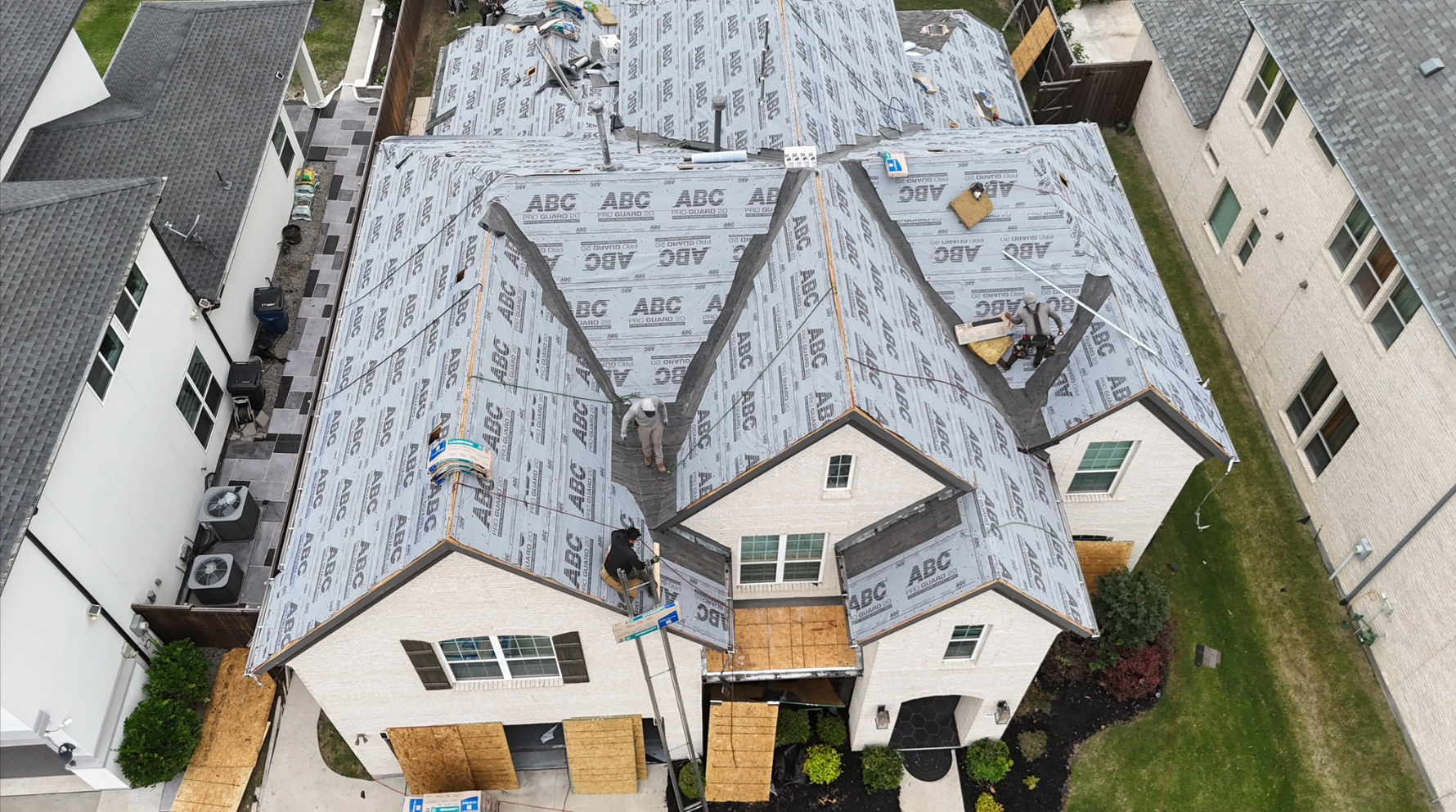 Aerial view of large home with full underlayment coverage