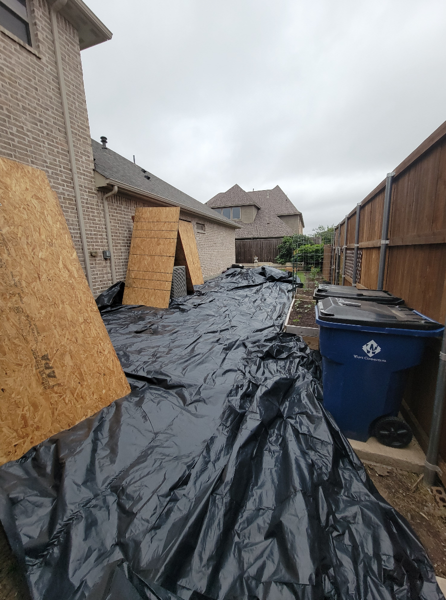 Backyard protected with tarps during roofing project