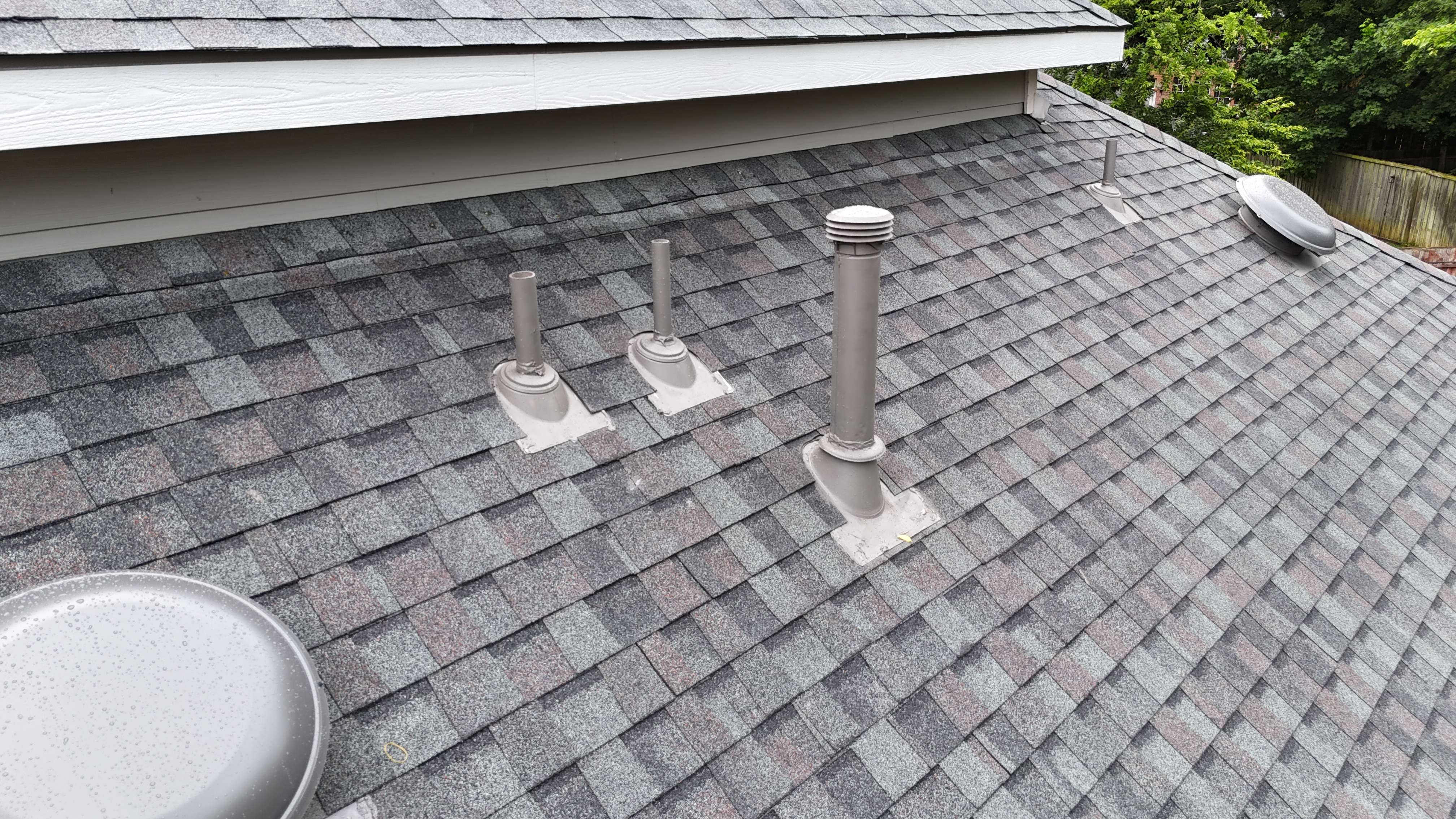 Close-up of new gray shingles with pipe boots and dome vents